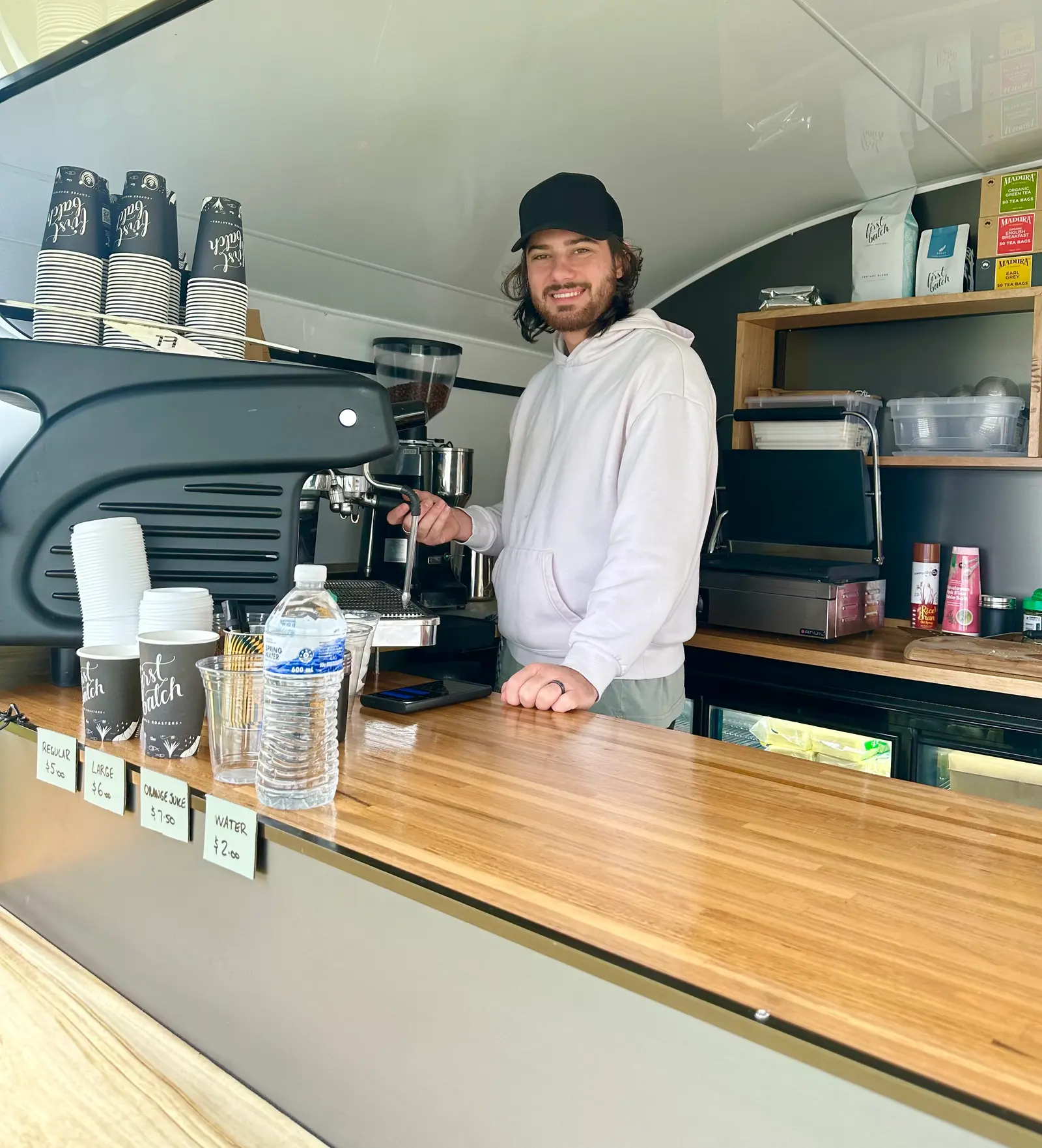 Barista inside the van beside the espresso machine